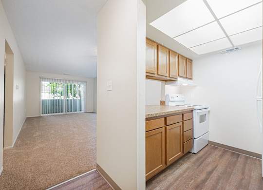 an empty kitchen and living room with wood flooring and a window