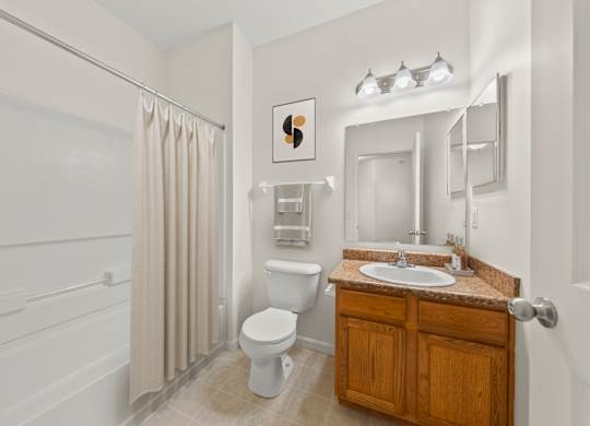 A bathroom with a toilet, sink, and shower.