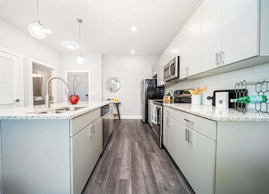 a kitchen with white cabinets and stainless steel appliances