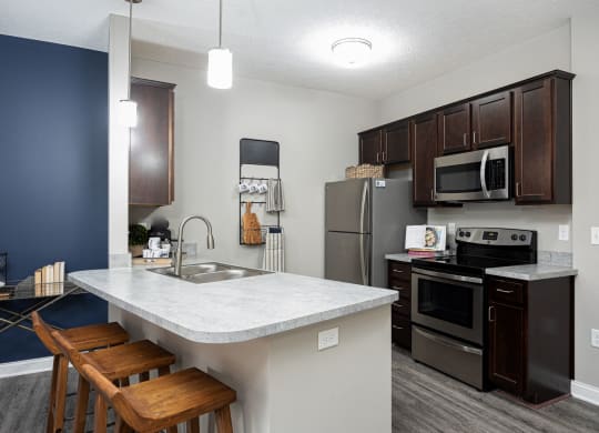 a kitchen with stainless steel appliances and a marble counter top