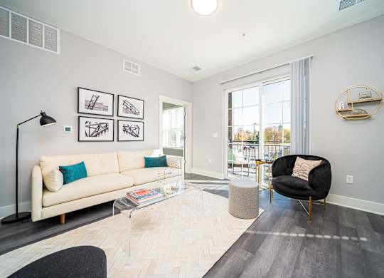 a living room with a couch and a chair and a window