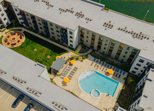 an aerial view of an apartment building with a swimming pool and a courtyard