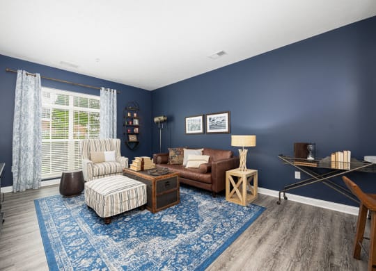 a living room with blue walls and a brown couch and chair