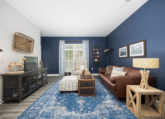 a living room with blue walls and a brown couch and a blue rug