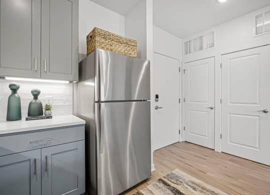 A modern kitchen with a stainless steel refrigerator and wooden countertop.