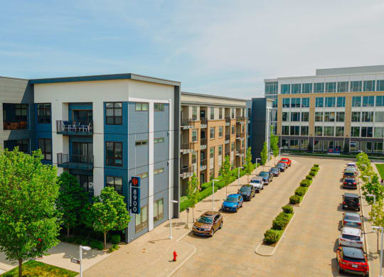 an aerial view of an apartment complex with cars parked in a parking lot