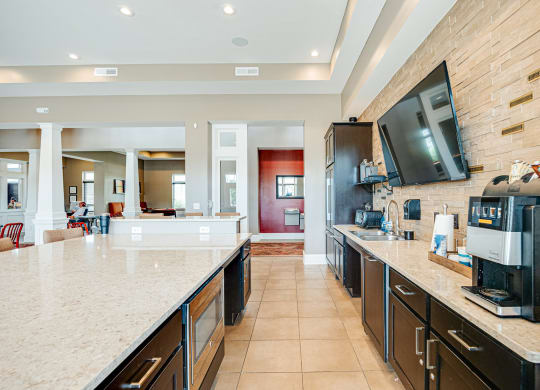 a large kitchen with a coffee machine and a television