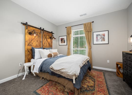 a bedroom with a bed and a window with a barn door
