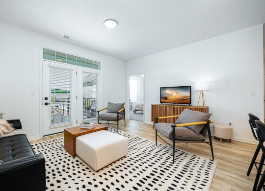 a living room with a couch and a chair and a television