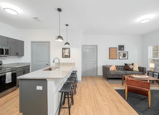 a kitchen with a long island and a living room with a couch
