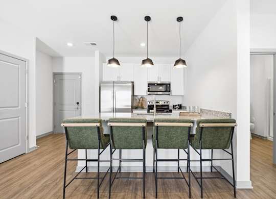 A kitchen with a table and chairs in the middle.