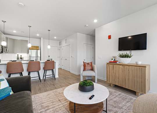 A living room with a white table and brown chairs.