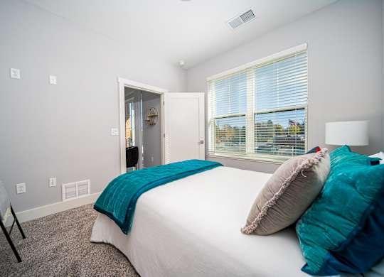 a bedroom with a bed and a large window