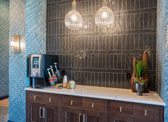 a coffee bar with a blue tiled wall and a coffee machine