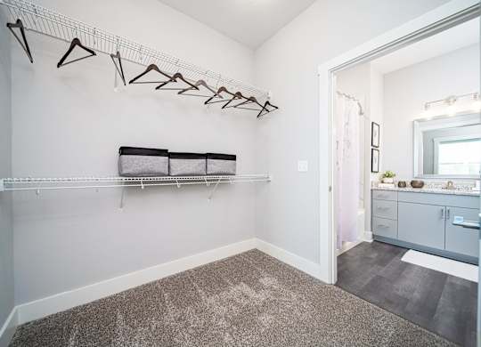 a white dressing room with a mirror and a bench