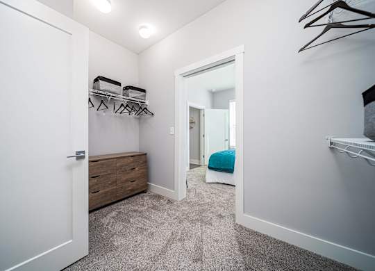 a closet in a bedroom with a bed and a mirror