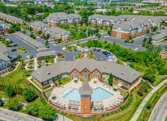 an aerial view of a building with a pool in a parking lot