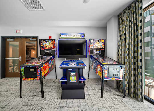 A room with two pinball machines and a table tennis table.