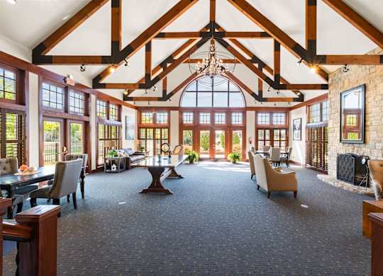 A large room with a high ceiling and a stone fireplace.