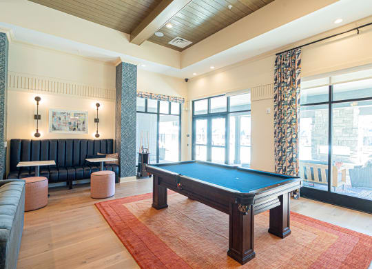 a game room with a pool table in the middle