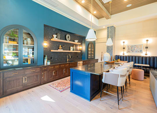 a large kitchen with blue cabinets and a table with chairs