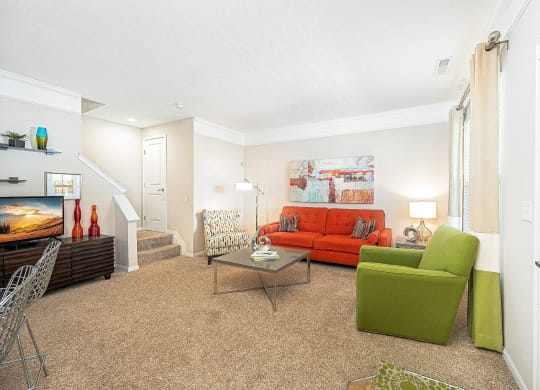 a living room with a red couch and a green chair