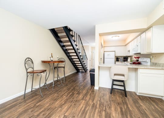a living room with a kitchen and a staircase