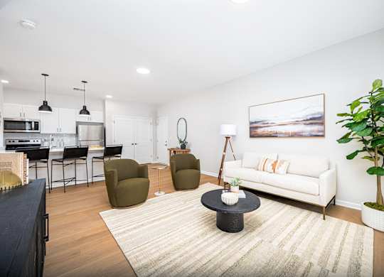 A living room with a white couch and a painting on the wall.