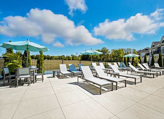 A sunny day at the outdoor pool area with lounge chairs and umbrellas.