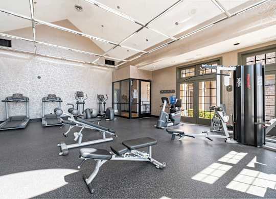 A gym with a variety of equipment including treadmills, weights, and exercise machines.