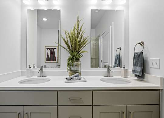 A bathroom with two sinks and a mirror.