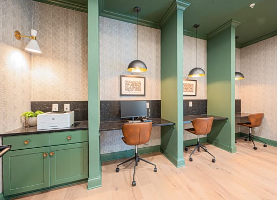 a home office with green cabinets and a desk with a computer
