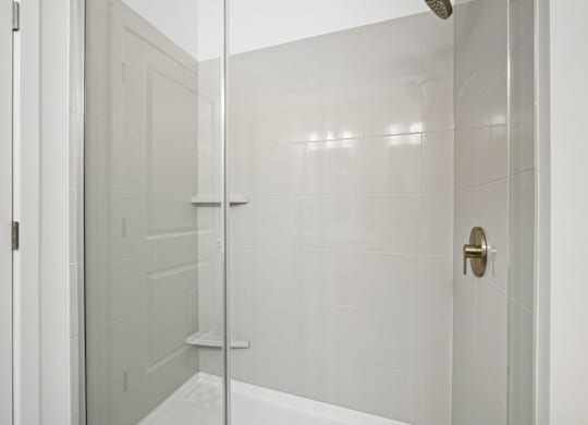 A white bathroom with a glass shower door.