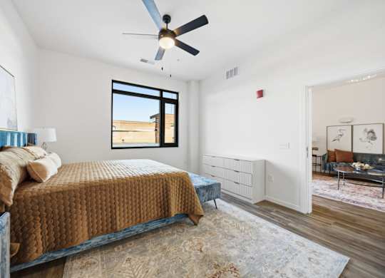 A bedroom with a bed, dresser, and window.