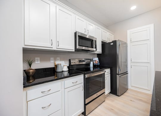 a kitchen with white cabinets and stainless steel appliances
