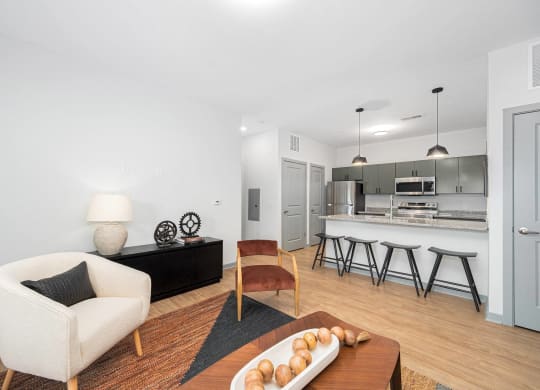 a living room with a couch and a chair and a kitchen
