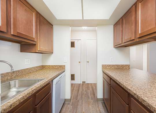 a kitchen with granite counter tops and wooden cabinets