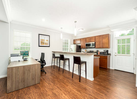 a living room with a kitchen and a bar with chairs
