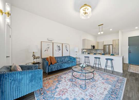 A living room with a blue couch and a rug.