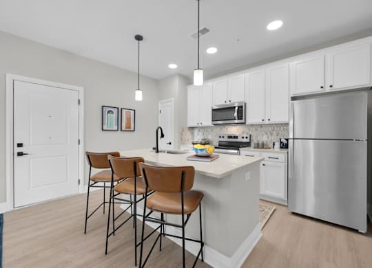 A kitchen with white cabinets and a stainless steel refrigerator.