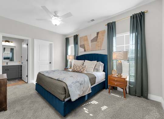 A bedroom with a large bed and a ceiling fan.