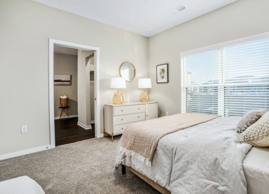 a bedroom with a bed and a large window