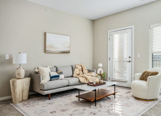 a living room with a couch and chairs and a coffee table