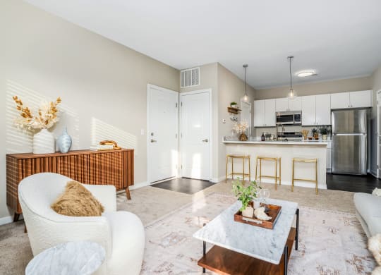 a living room with a couch and a coffee table in front of a kitchen