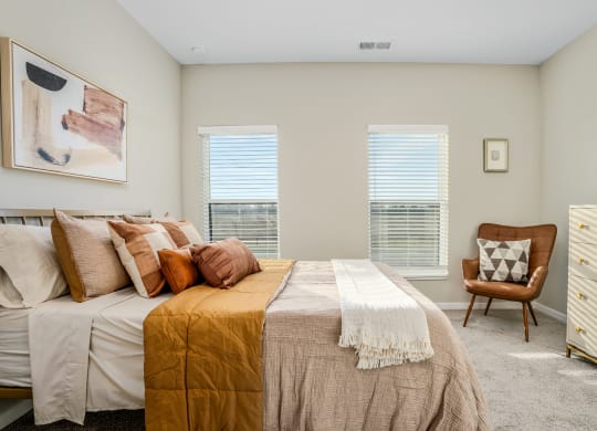 a bedroom with a bed and two windows