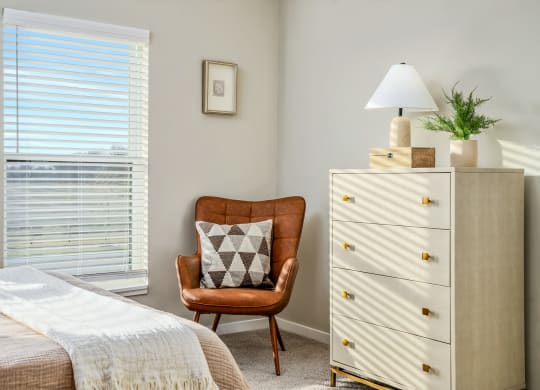 a bedroom with a bed and a chair and a dresser