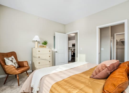 a bedroom with a bed and a chair and a closet