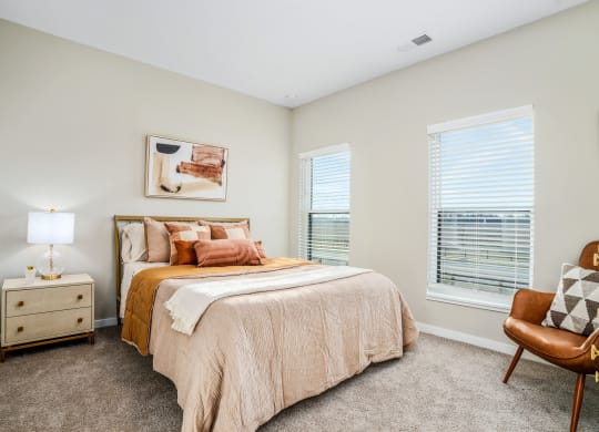 a bedroom with a bed and two windows