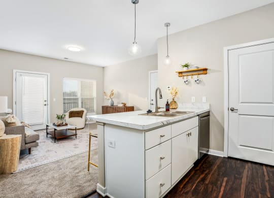 a renovated kitchen with white cabinets and a living room