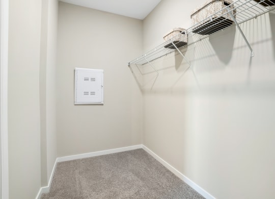 an empty closet with a wire basket hanging on the wall